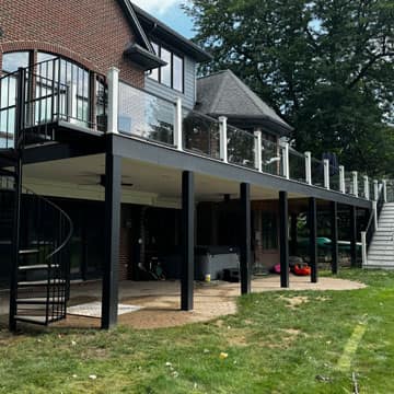 Deck with wide staircase leading to a landscaped yard