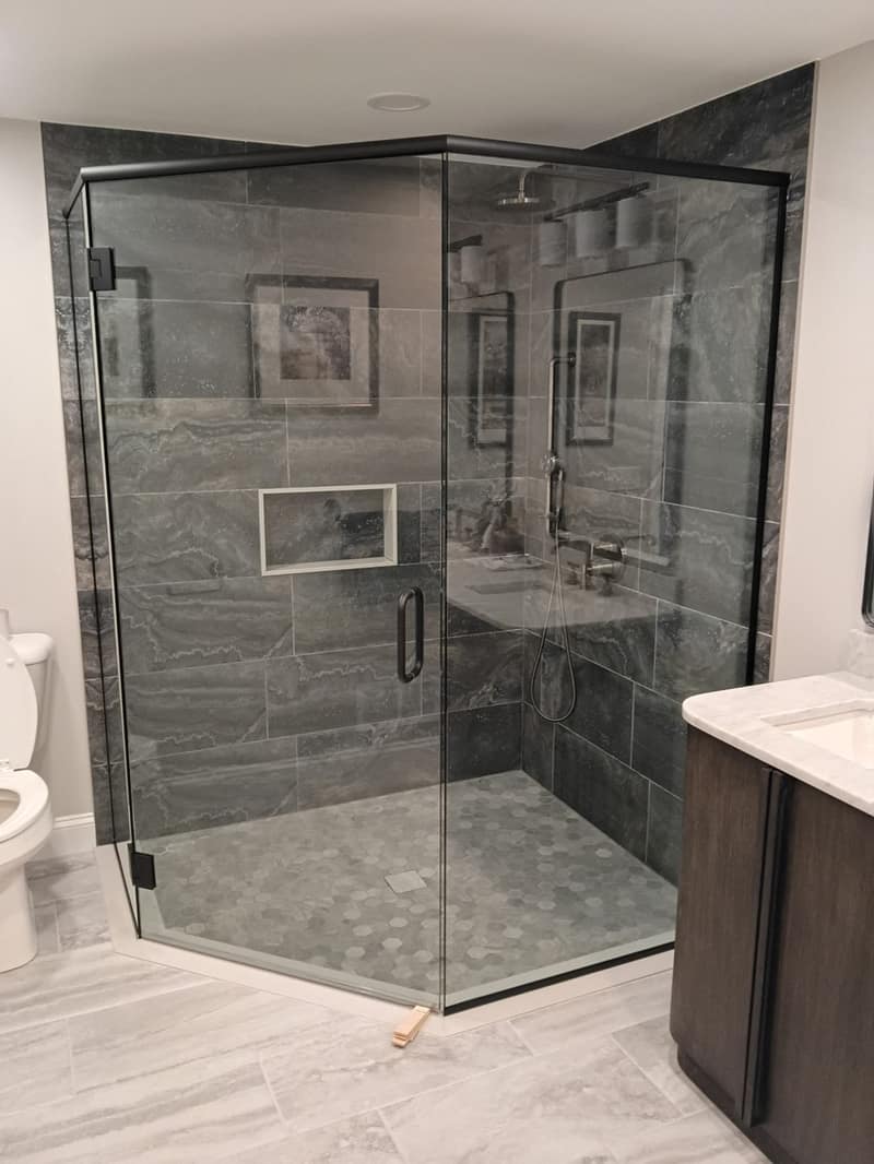 Walk-in glass shower with gray tile and built-in niche from a bathroom remodel by All American Remod